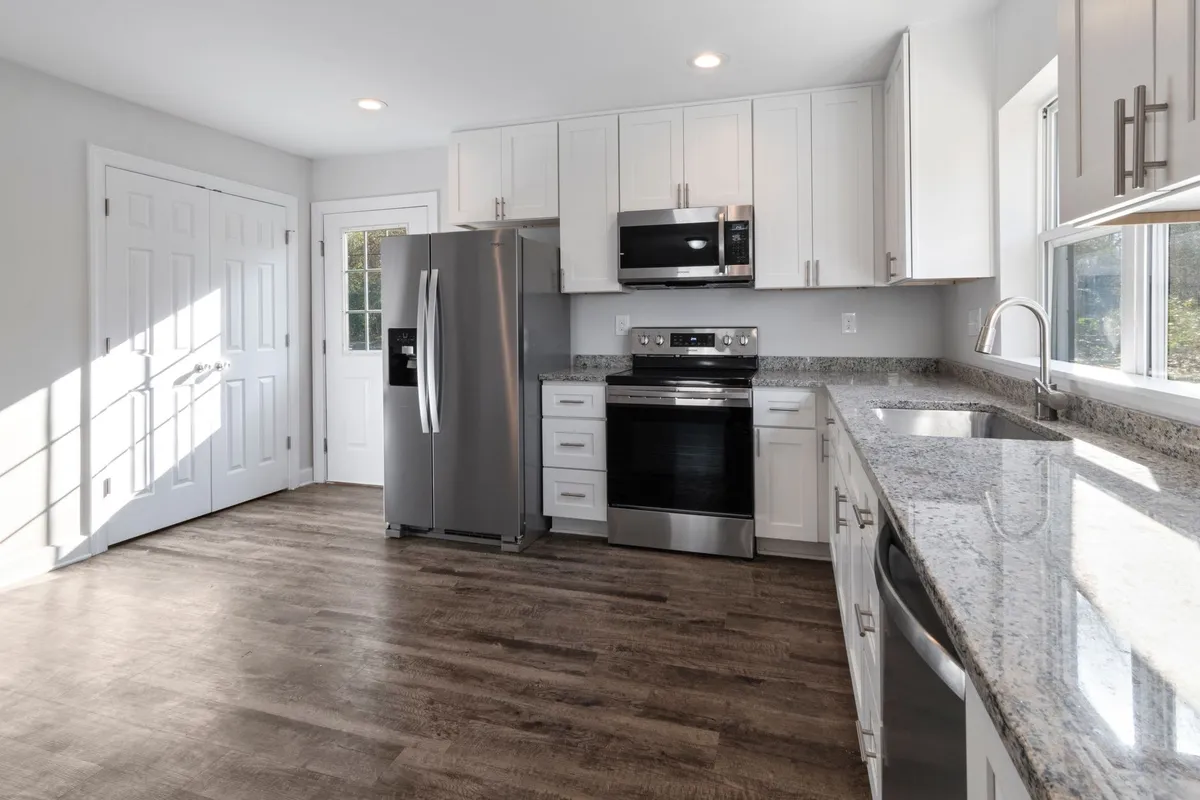 A bright modern kitchen with stainless steel appliances and granite countertops, symbolizing homeownership solutions.